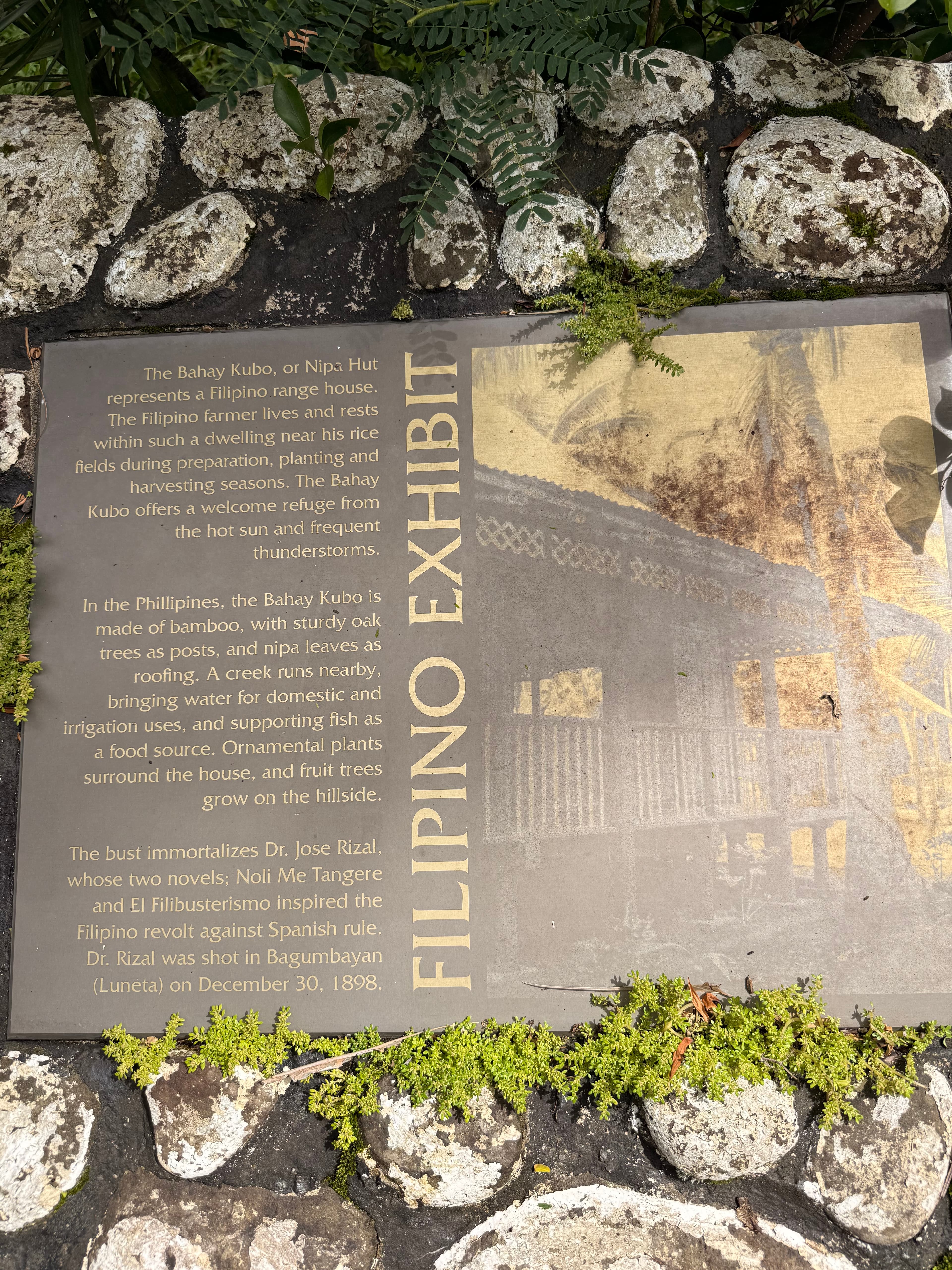 Stone-mounted Filipino Exhibit plaque with text and an illustration of a bahay kubo